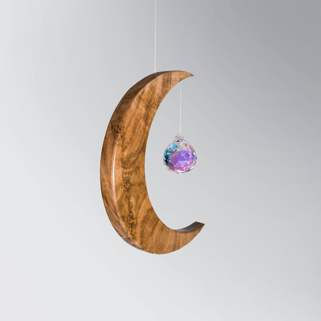 Signature Crescent Mond Sonnenfänger: Handcrafted Oak Wood Moon with 4cm Asfour Kristallprisma hanging in sunlight.