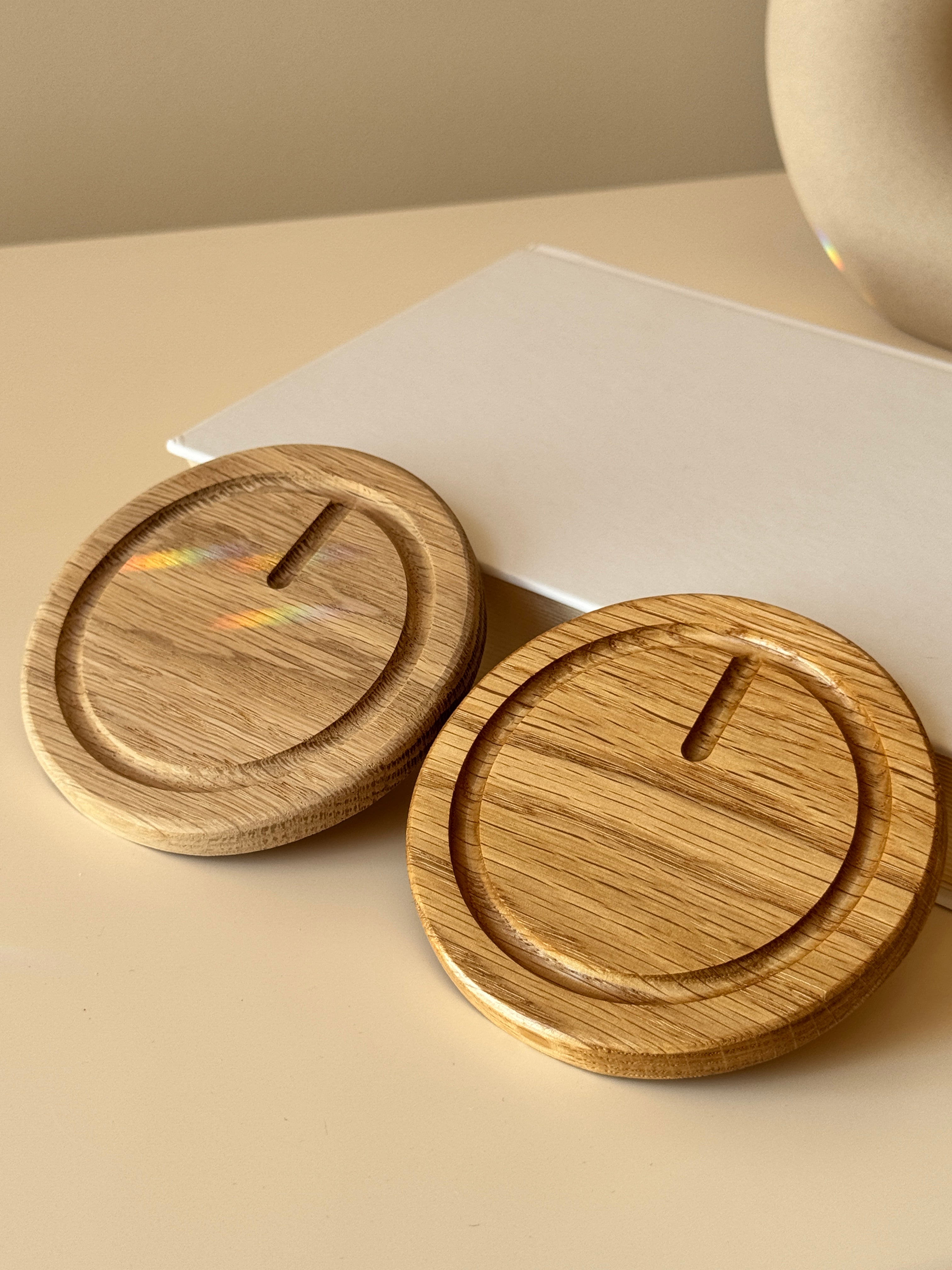 Two wooden coasters on a beige surface