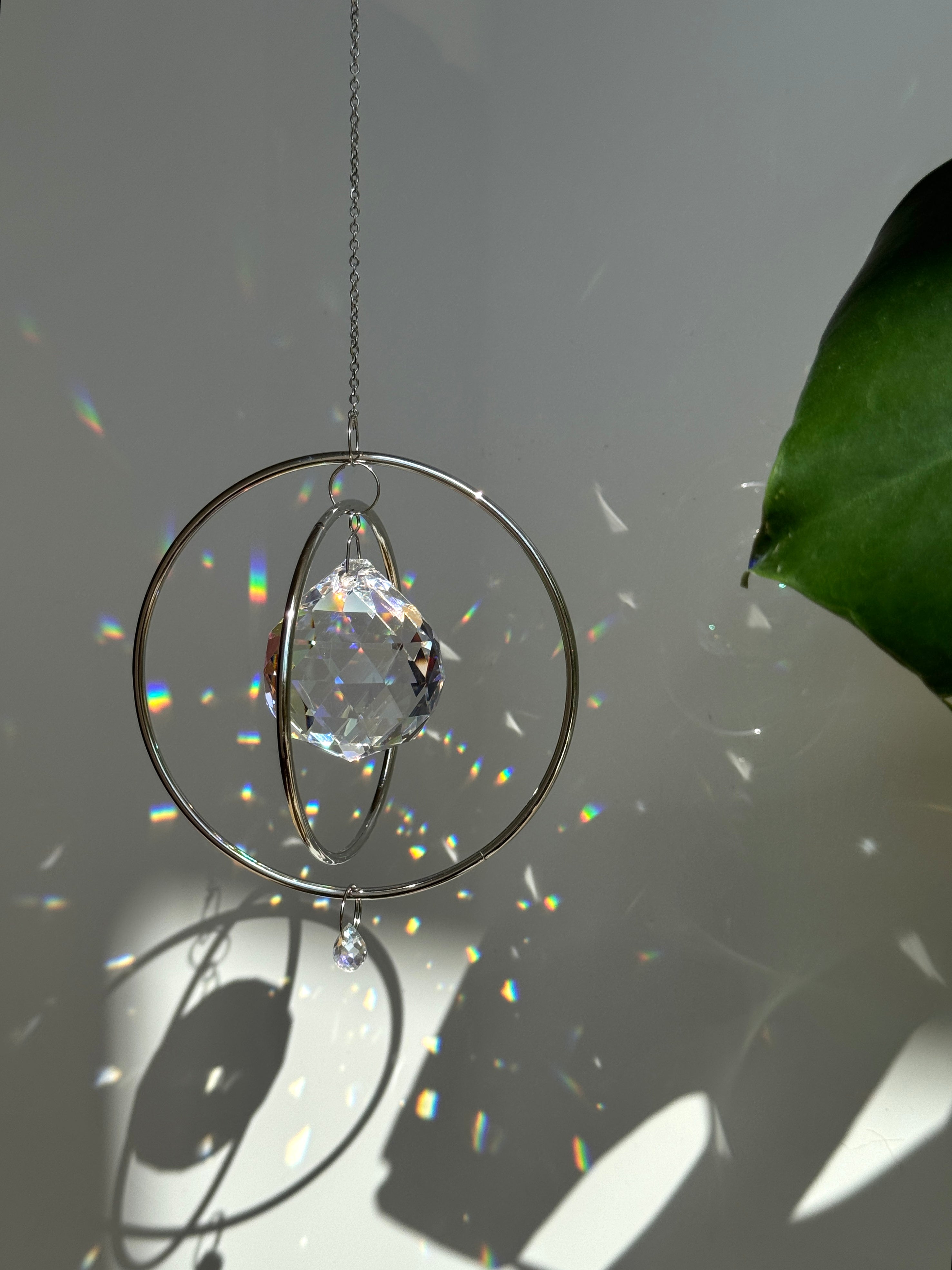 Gold Orbit suncatcher with a 40mm Asfour crystal prism. Minimalistischer Sonnenfänger for home decor casting rainbow light and beautiful Lichtreflexe on the wall. Boho-Stil window decoration and Regenbogenmacher.