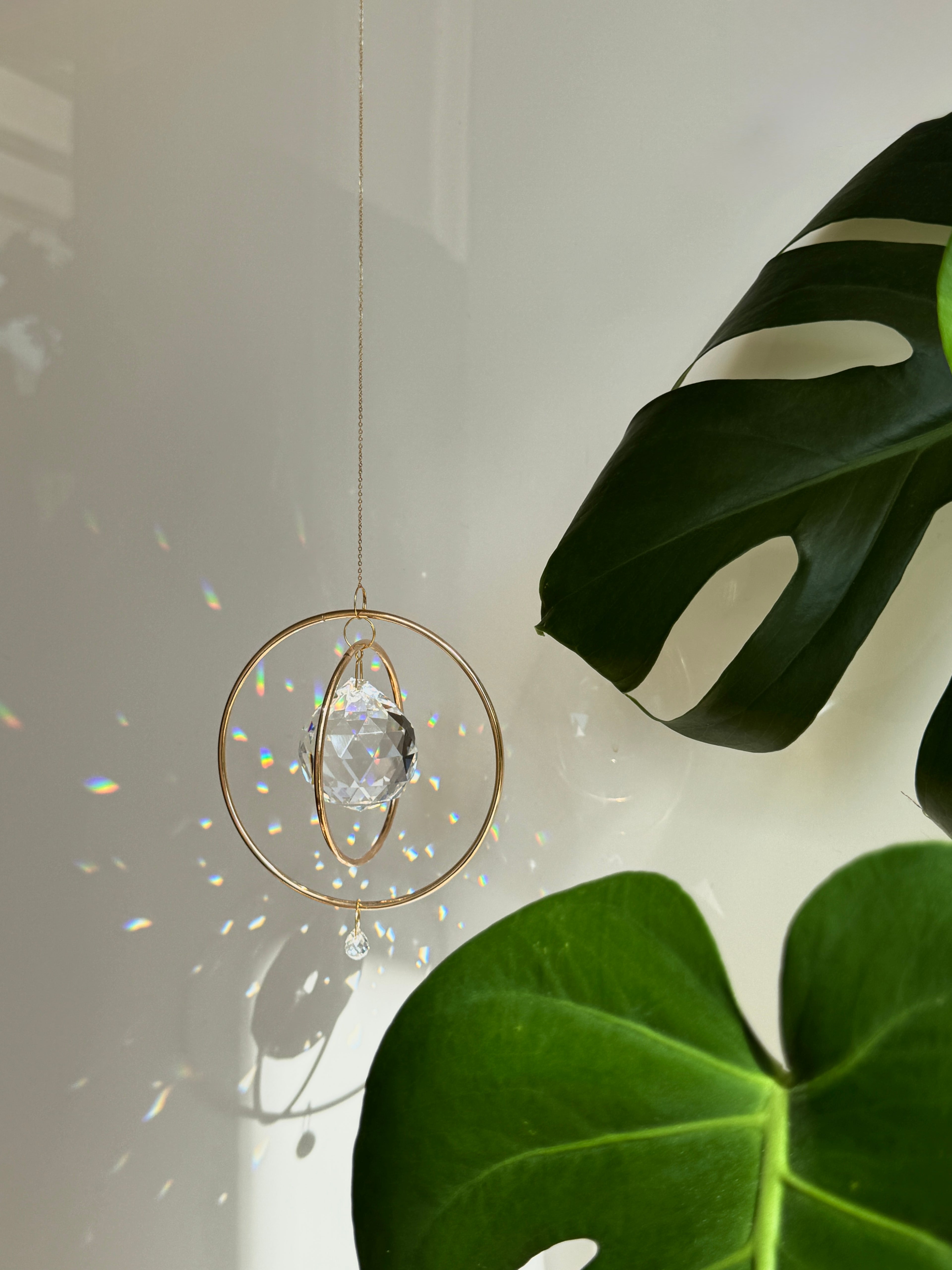 Gold Orbit suncatcher with a 40mm Asfour crystal prism. Minimalistischer Sonnenfänger for home decor casting rainbow light and beautiful Lichtreflexe on the wall. Boho-Stil window decoration and Regenbogenmacher.