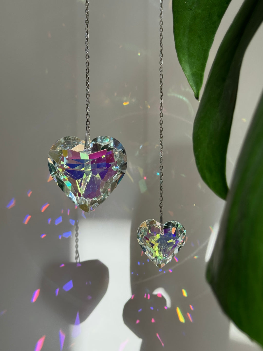 A romantic 'Sweet Reflection' crystal suncatcher creating a rainbow light show in a sunny window—a perfect Valentine's Day gift or home patio decoration.