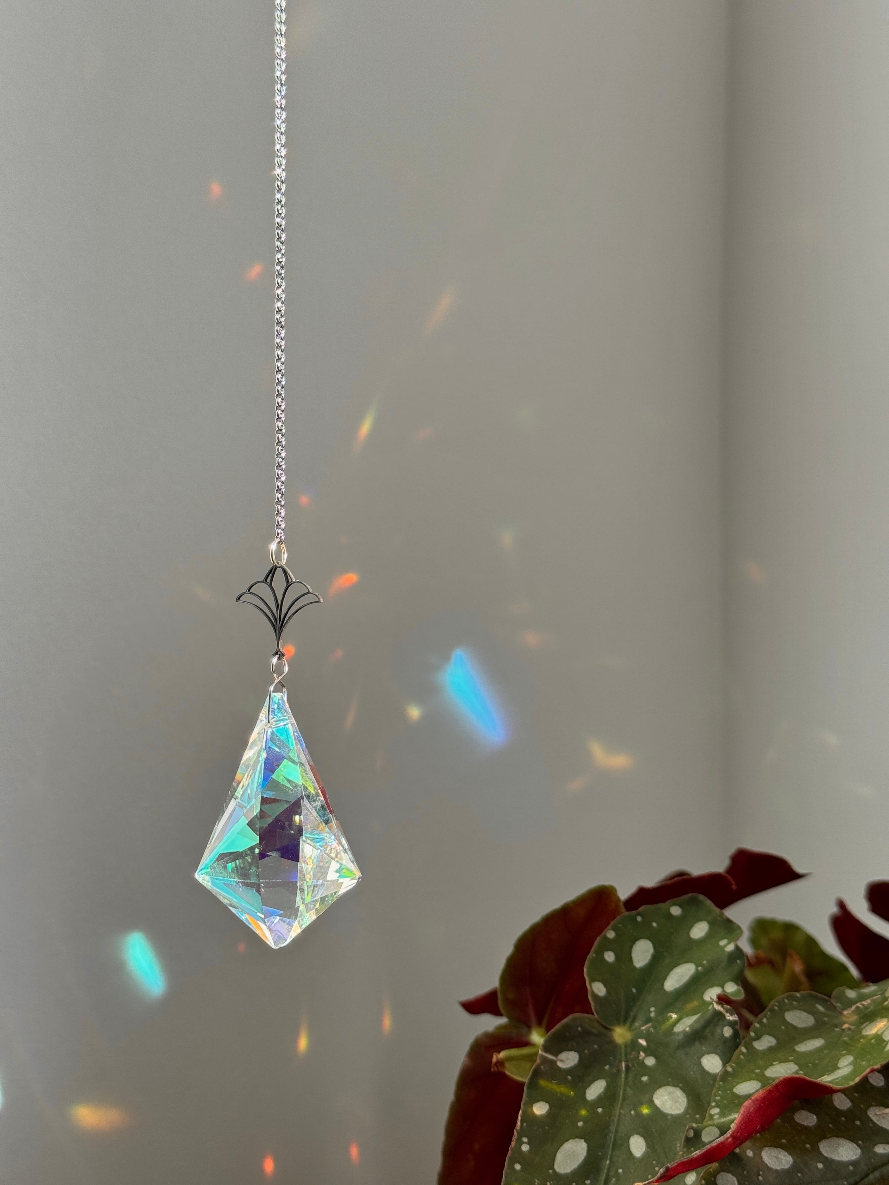 Victorian Fleur suncatcher (Sonnenfänger) with a 7.5cm faceted crystal and elegant silver details, scattering rainbows (Regenbogen) across a sunlit room.
