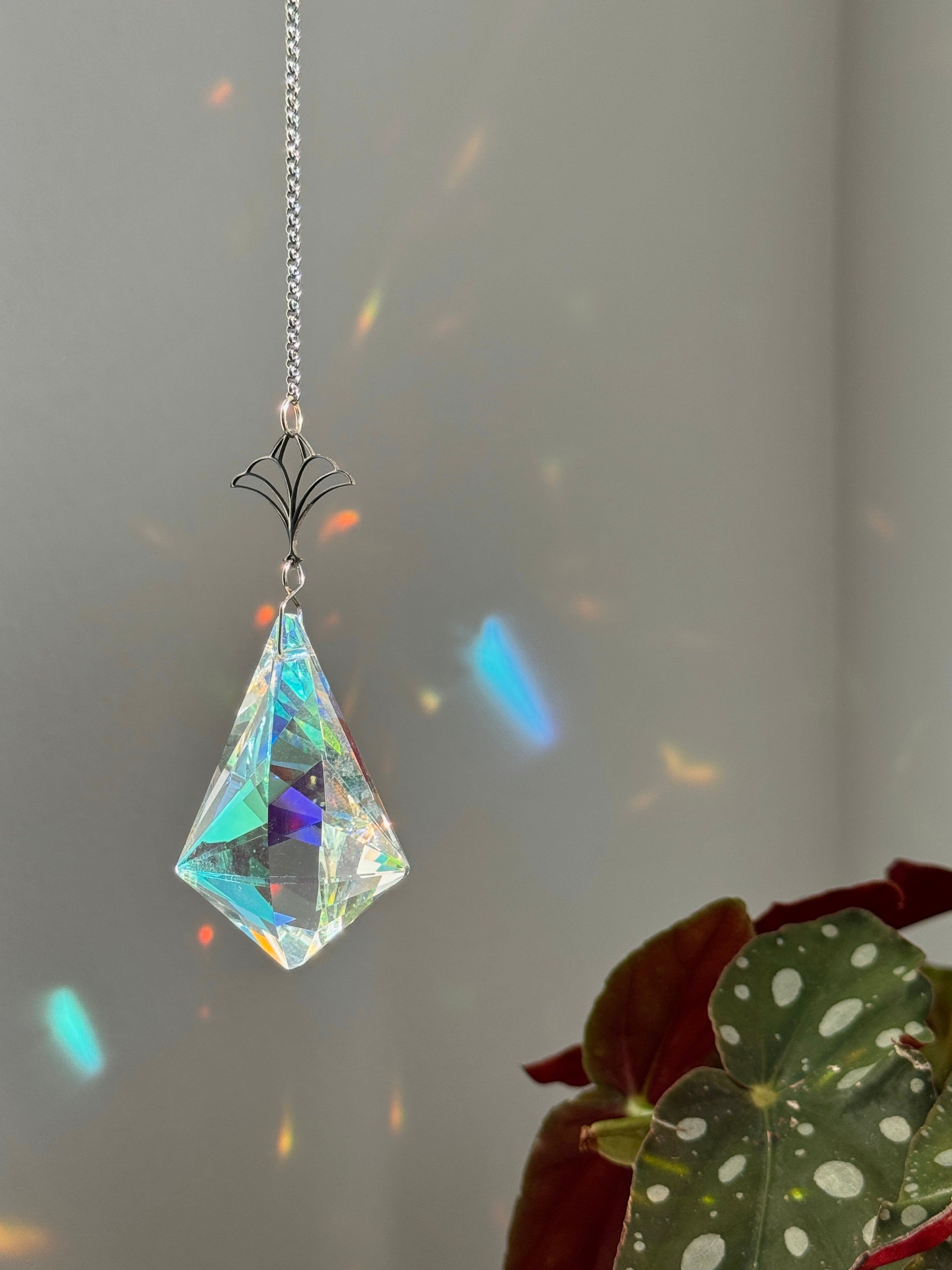 Close-up of the silver-toned Victorian-style accents and the large faceted crystal prism (Kristall) of the Victorian Fleur window decoration.