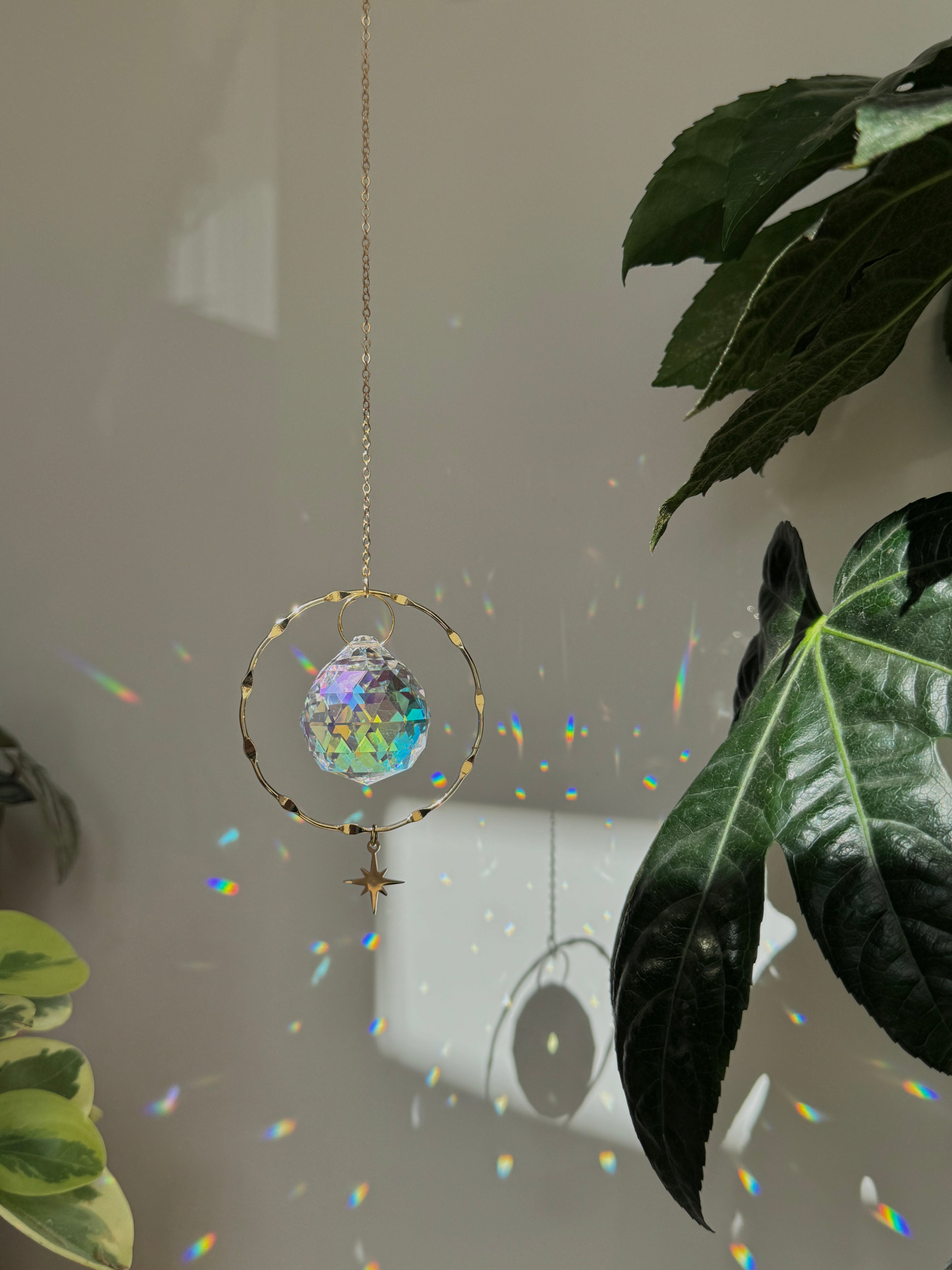 Crystal rainbow maker casting vibrant light reflections and rainbows on a sunlit wall for boho home decor.