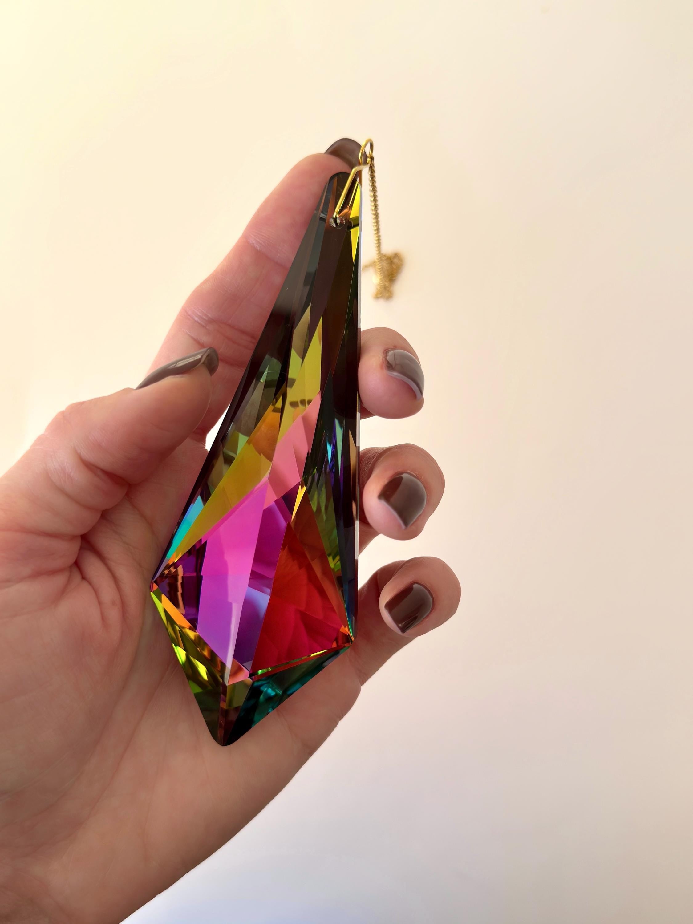 Large Vivid Geometry suncatcher (Sonnenfänger) casting deep green and gold rainbows (Regenbogen) on a white wall from a 12cm Aurora Borealis crystal.