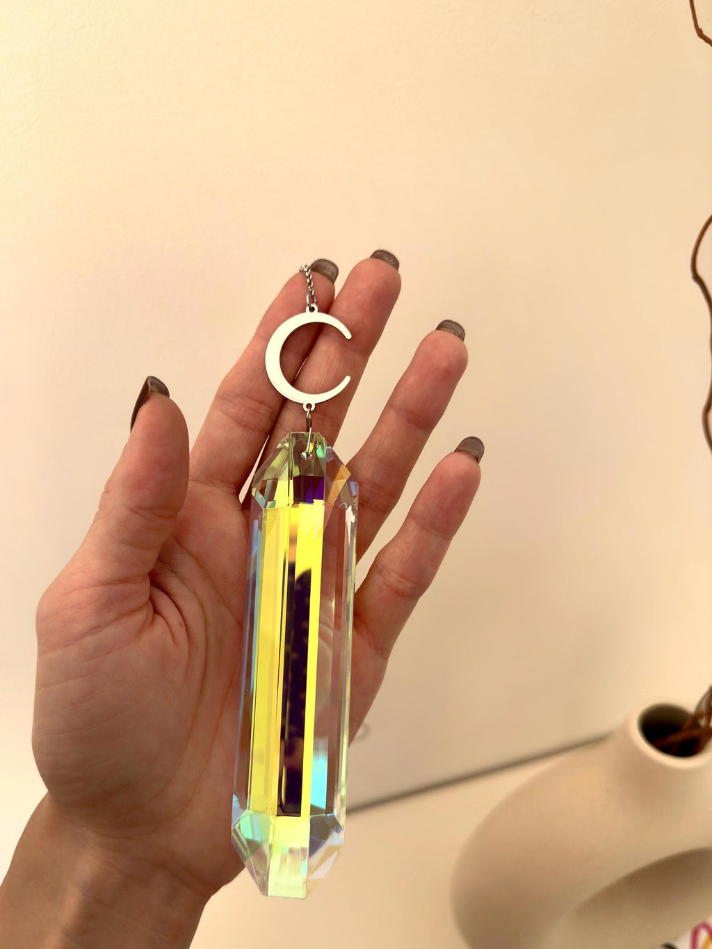 Luminescence celestial suncatcher (Sonnenfänger) with a silver crescent moon and 12 cm Aurora crystal prism scattering rainbows (Regenbogen) across a room.