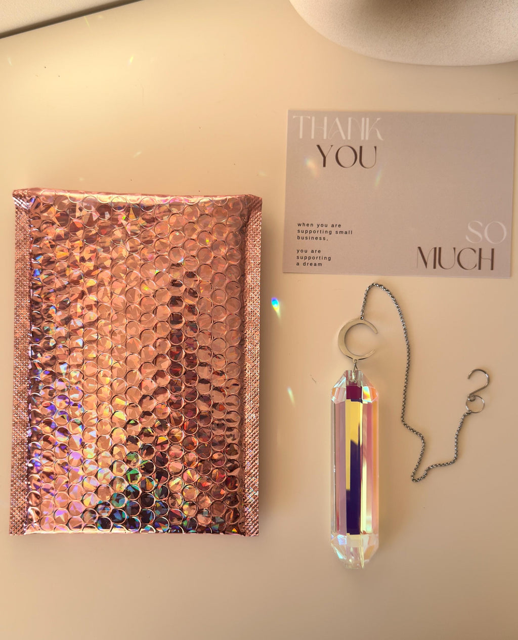 Luminescence celestial suncatcher (Sonnenfänger) with a silver crescent moon and 12 cm Aurora crystal prism scattering rainbows (Regenbogen) across a room.