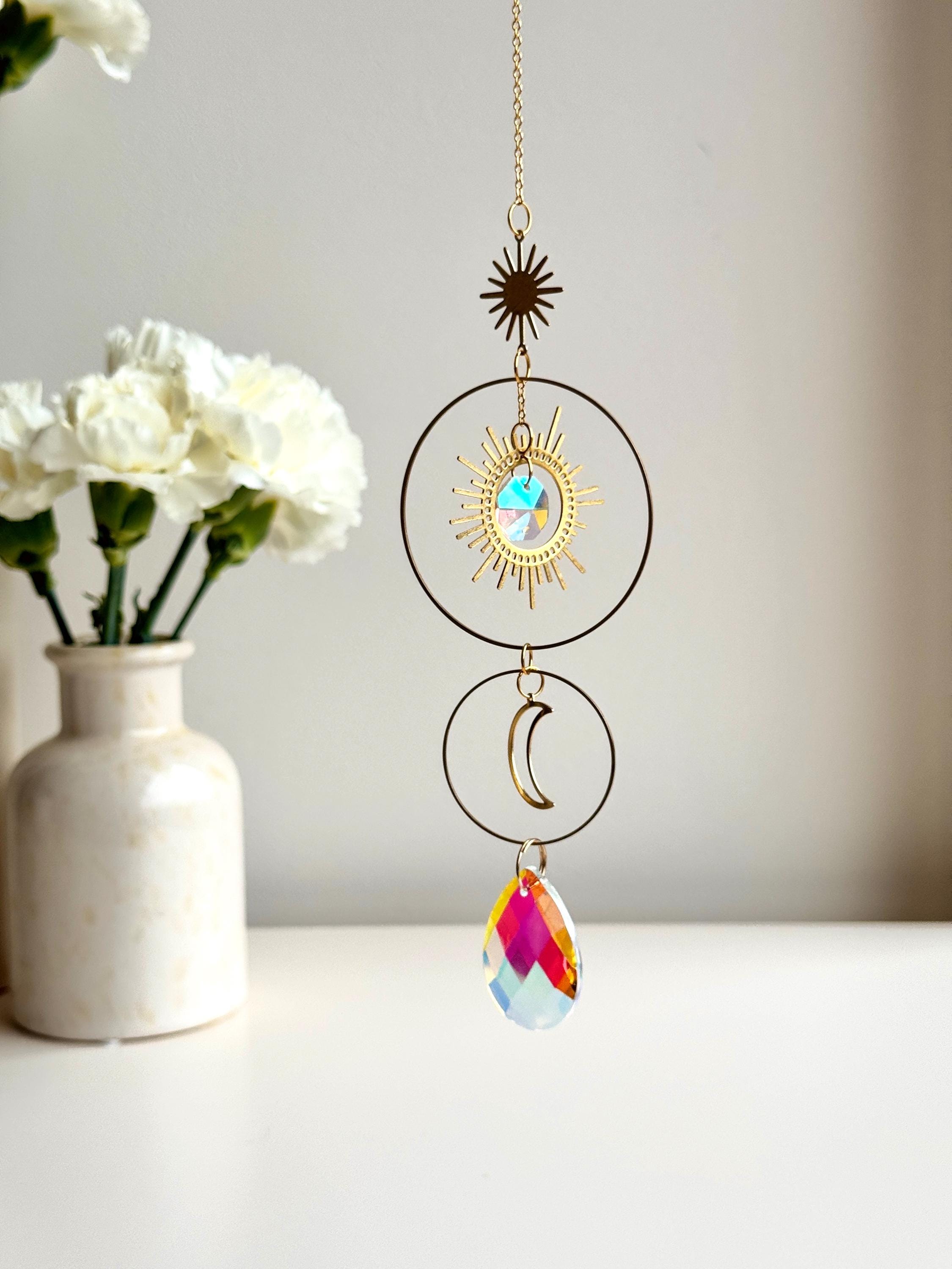 Large 4cm crystal suncatcher 'Sun's Droplet' hanging on a 40cm chain, creating brilliant rainbow patterns on a neutral wall in a sunny room.
