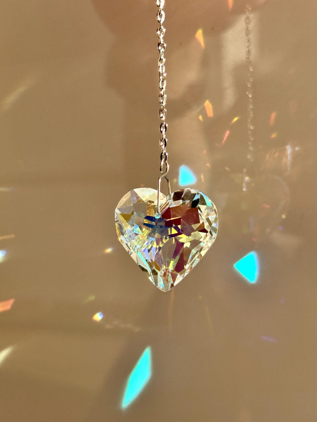 A romantic 'Sweet Reflection' crystal suncatcher creating a rainbow light show in a sunny window—a perfect Valentine's Day gift or home patio decoration.