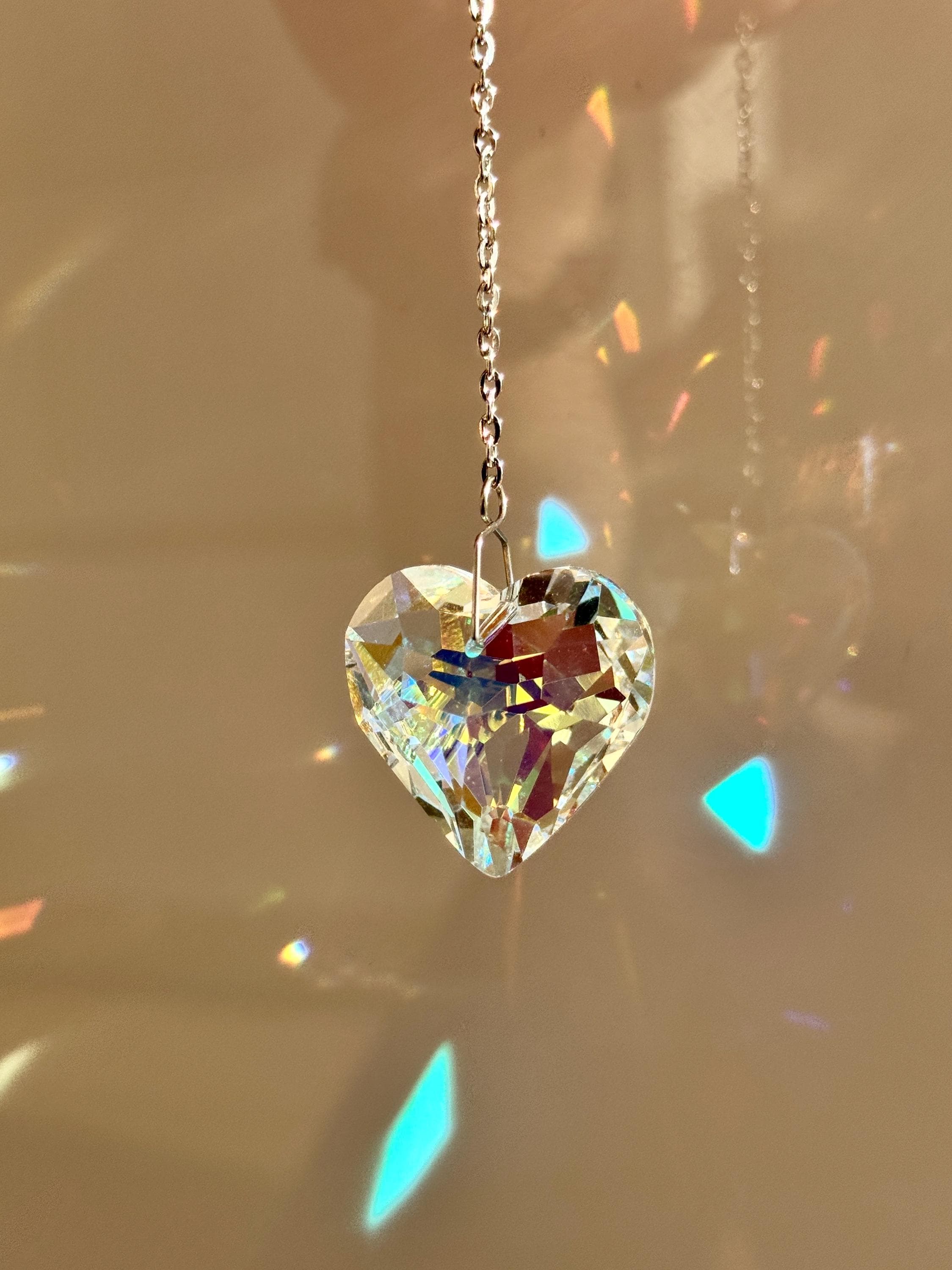A romantic 'Sweet Reflection' crystal suncatcher creating a rainbow light show in a sunny window—a perfect Valentine's Day gift or home patio decoration.