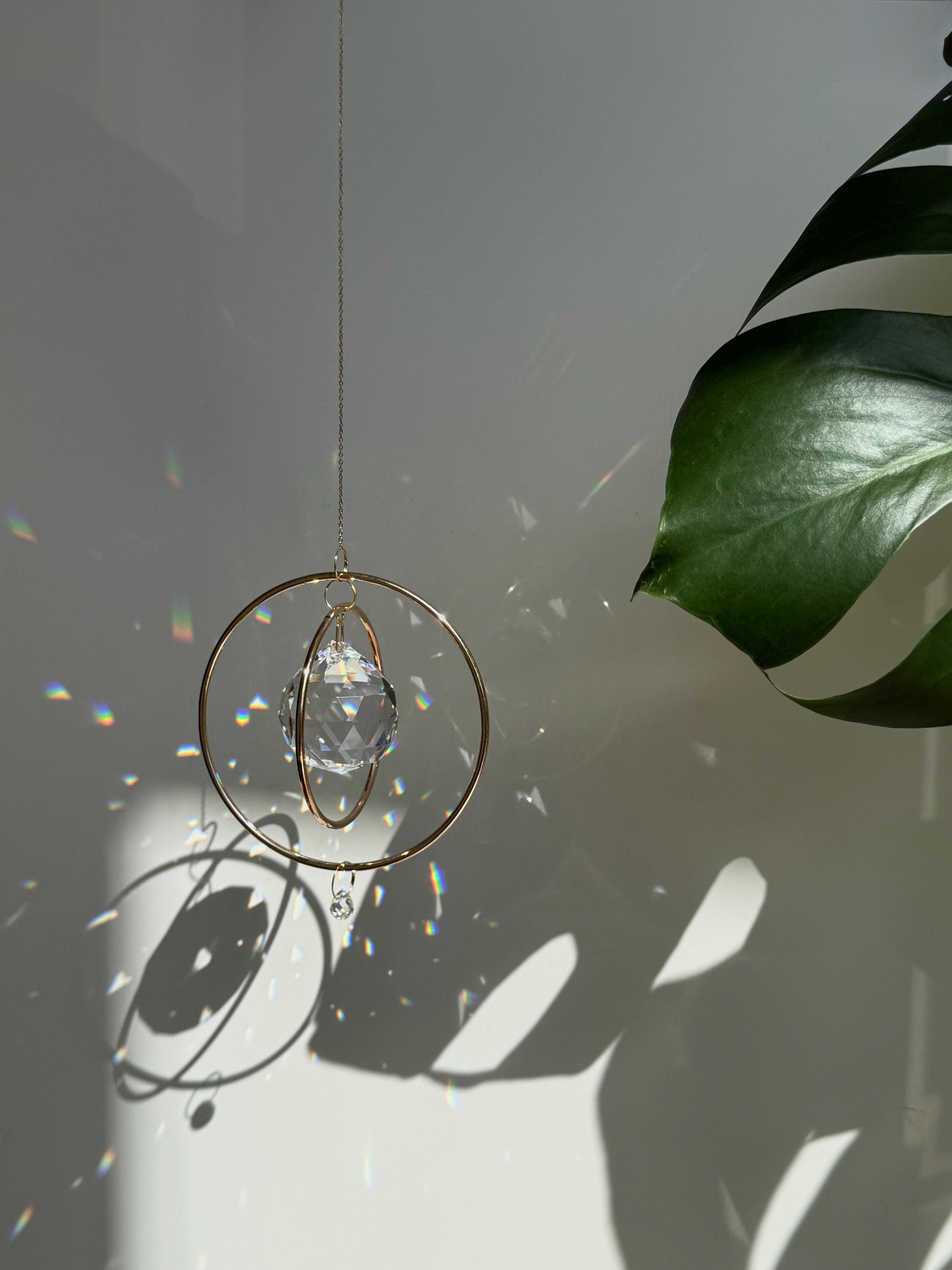 Gold Orbit suncatcher with a 40mm Asfour crystal prism. Minimalistischer Sonnenfänger for home decor casting rainbow light and beautiful Lichtreflexe on the wall. Boho-Stil window decoration and Regenbogenmacher.
