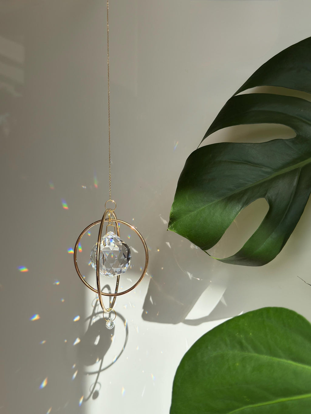 Gold Orbit suncatcher with a 40mm Asfour crystal prism. Minimalistischer Sonnenfänger for home decor casting rainbow light and beautiful Lichtreflexe on the wall. Boho-Stil window decoration and Regenbogenmacher.