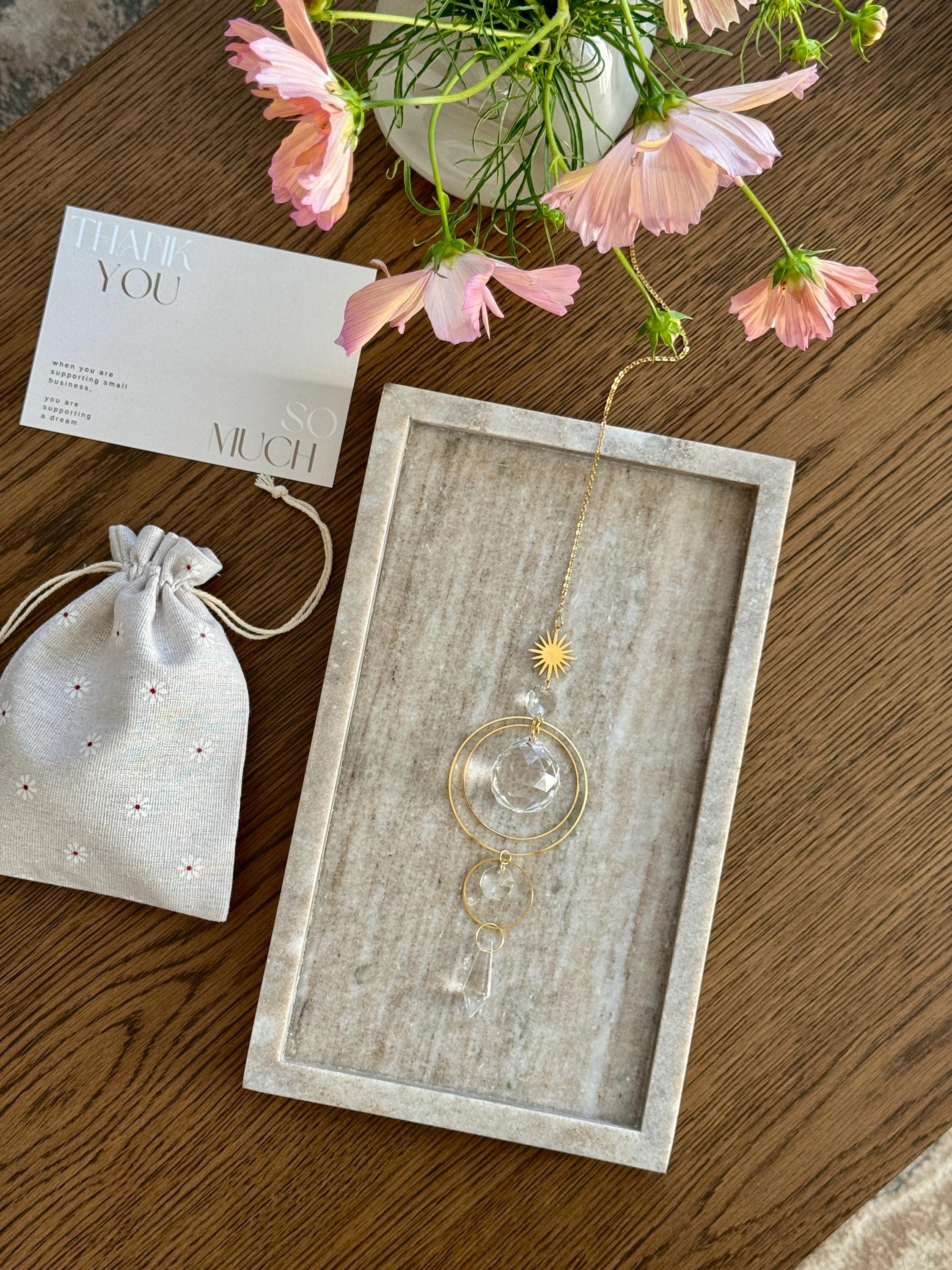 Handmade gold suncatcher tucked inside a signature cream linen gift bag, sustainable gift packaging.