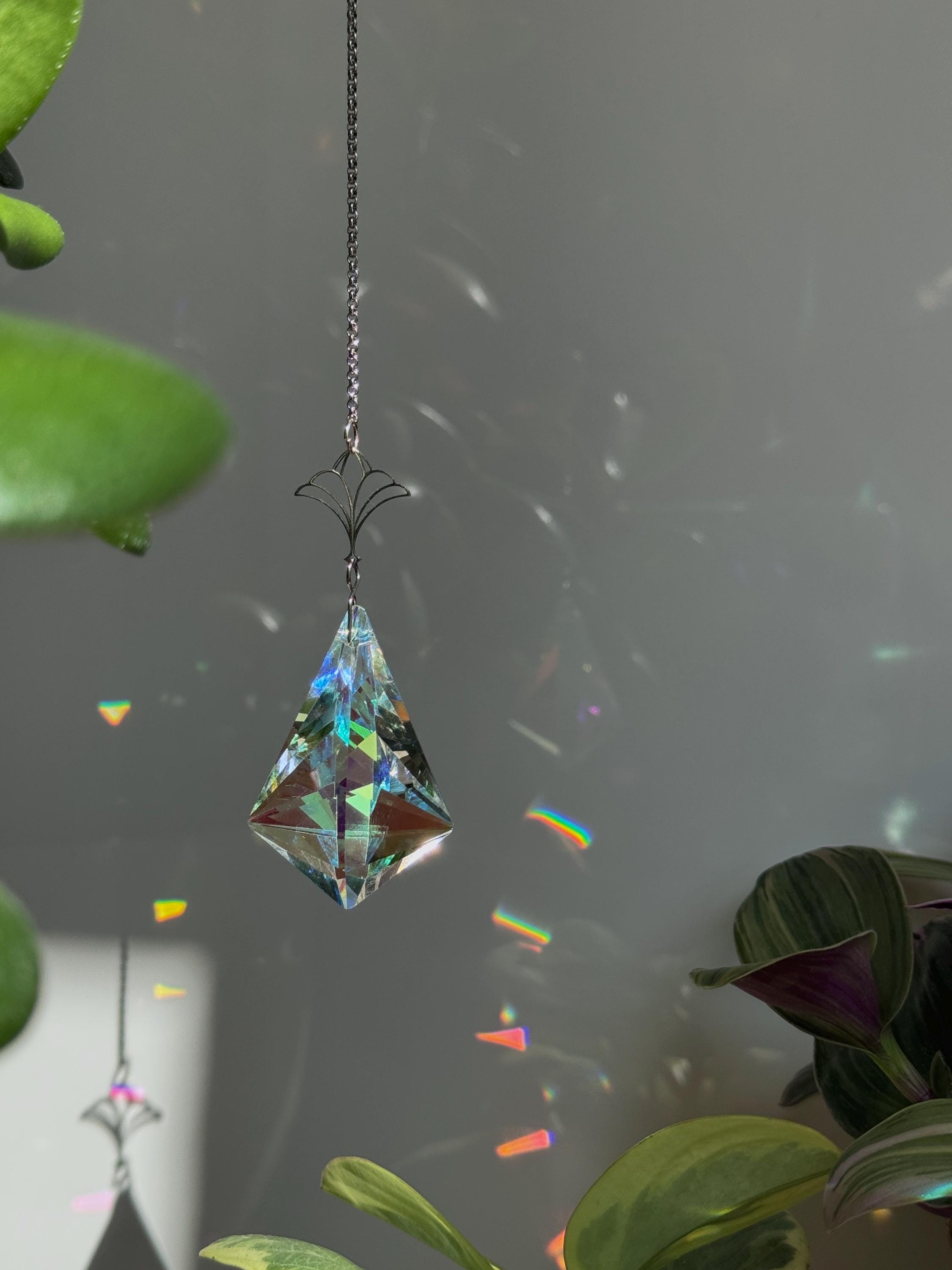 Victorian Fleur suncatcher (Sonnenfänger) with a 7.5cm faceted crystal and elegant silver details, scattering rainbows (Regenbogen) across a sunlit room.