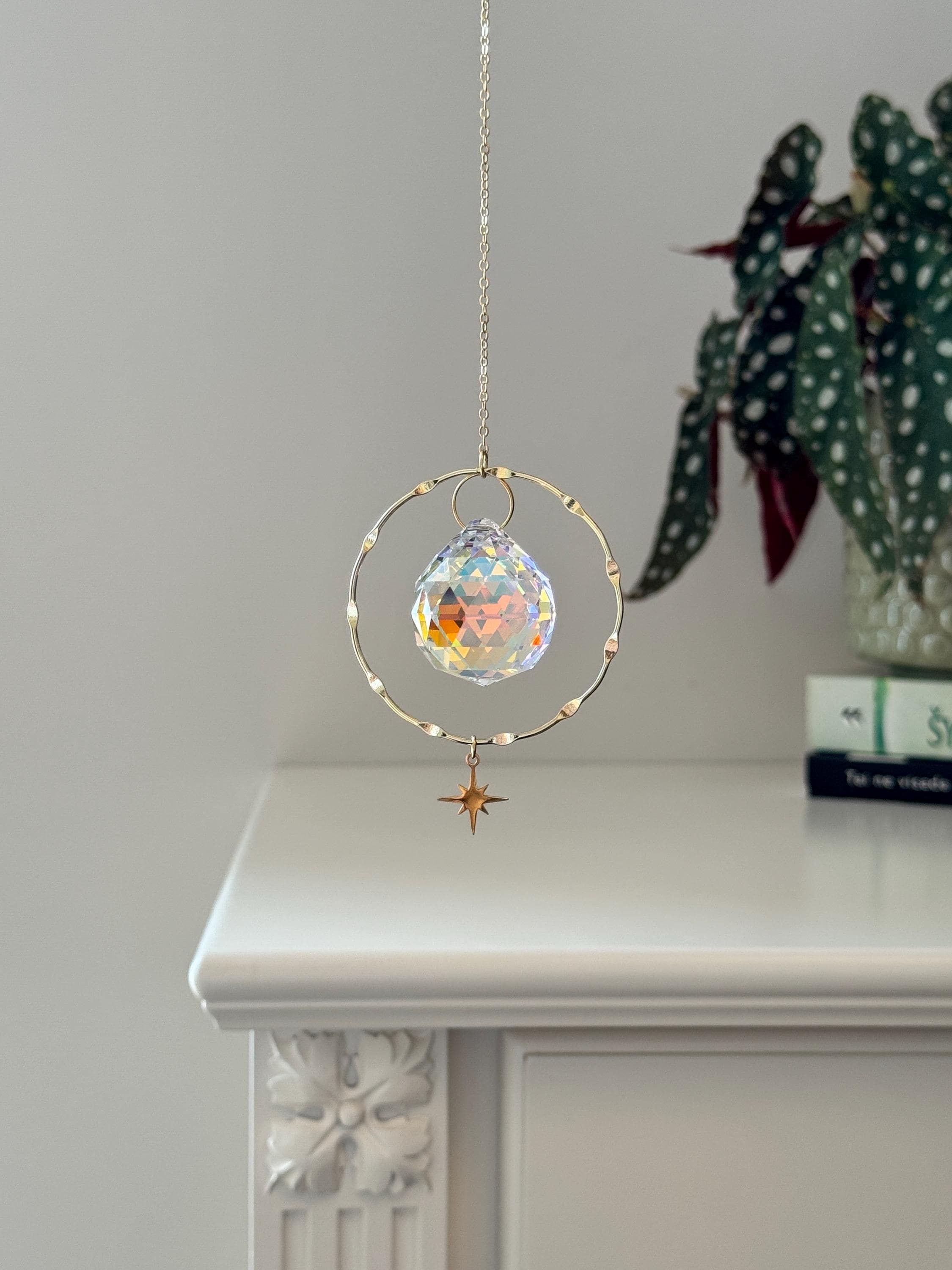 Handcrafted gold-plated suncatcher featuring a 3cm faceted crystal prism and a delicate celestial star charm.
