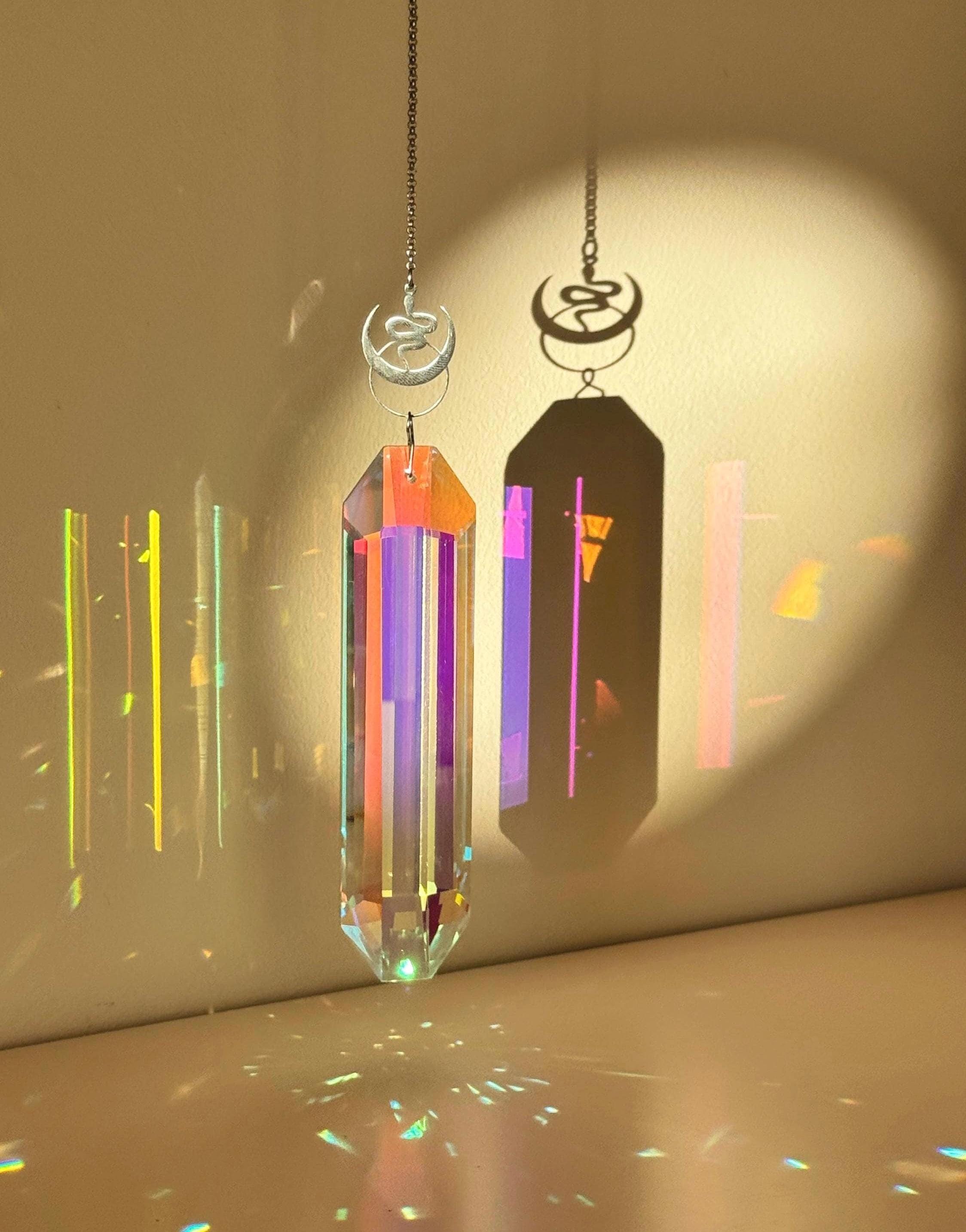 Alchemist's Shadow celestial suncatcher (Sonnenfänger) with a silver snake and moon charm, featuring a 12cm Aurora crystal casting rainbows (Regenbogen).