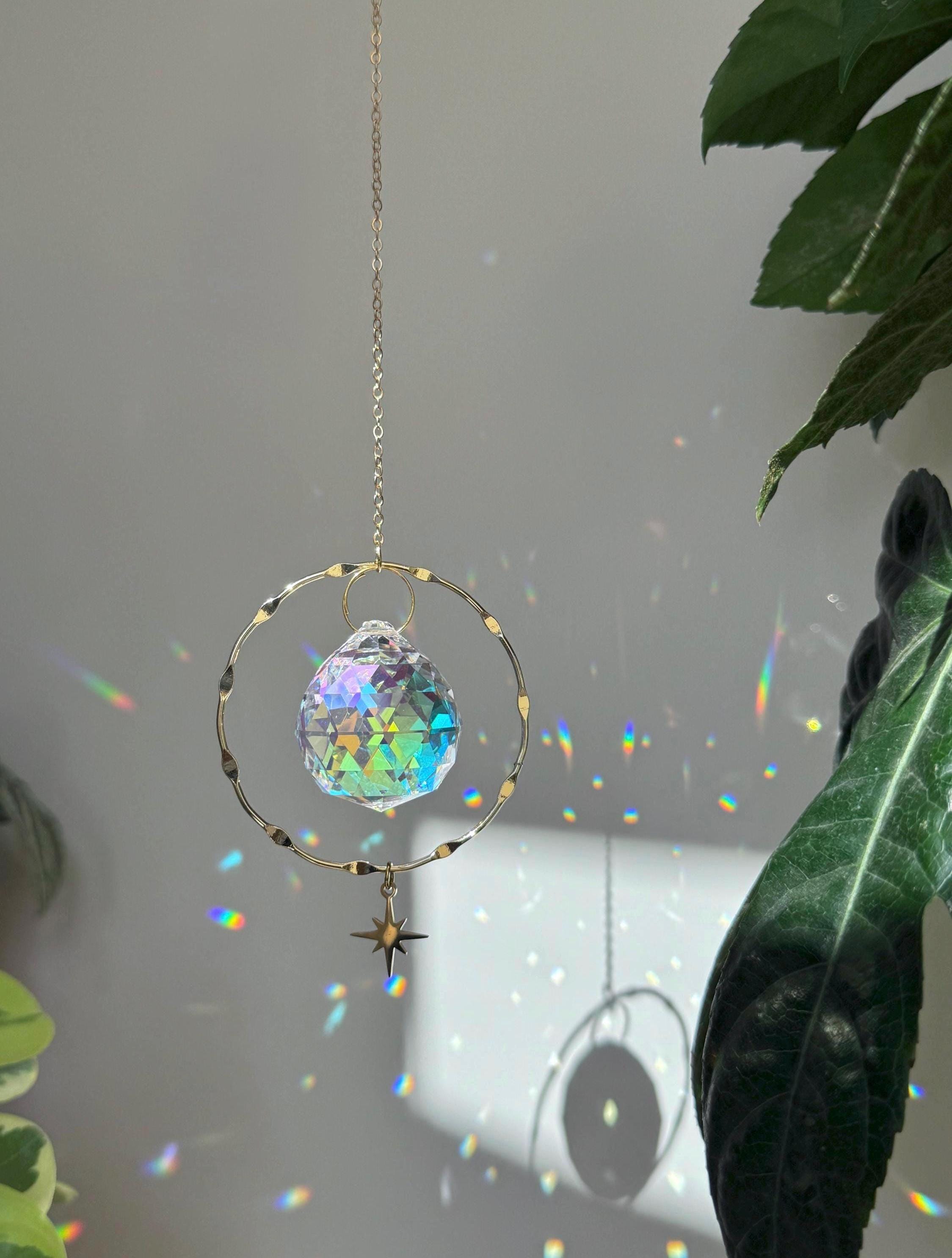 Crystal rainbow maker casting vibrant light reflections and rainbows on a sunlit wall for boho home decor.