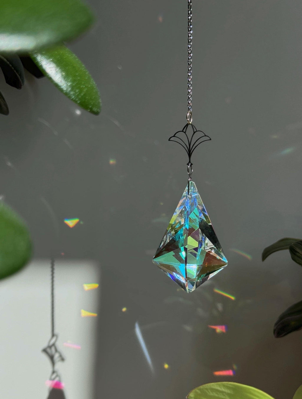 Victorian Fleur suncatcher (Sonnenfänger) with a 7.5cm faceted crystal and elegant silver details, scattering rainbows (Regenbogen) across a sunlit room.